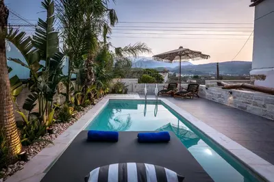 a swimming pool with two chairs and an umbrella at Villa Armenus, private pool, garden, BBQ in Chania Town
