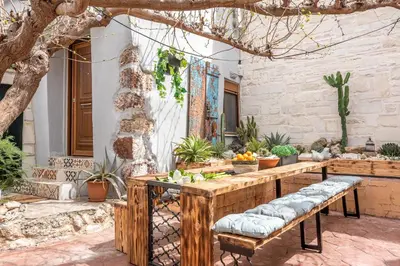 a patio with a table and benches with plants at Villa Armenus, private pool, garden, BBQ in Chania Town