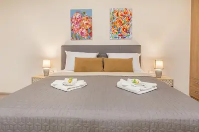 a bedroom with a large bed with towels on it at Gallery Art Apartment Chania Crete in Chania Town