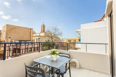 a patio with a table and chairs on a balcony at Gallery Art Apartment Chania Crete in Chania Town