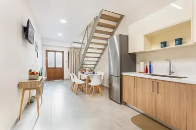 a kitchen and dining room with a spiral staircase at Gallery Art Apartment Chania Crete in Chania Town
