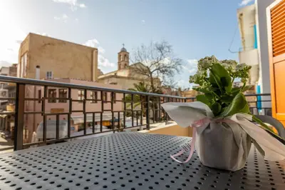 a vase of flowers sitting on a table on a balcony at Gallery Art Apartment Chania Crete in Chania Town