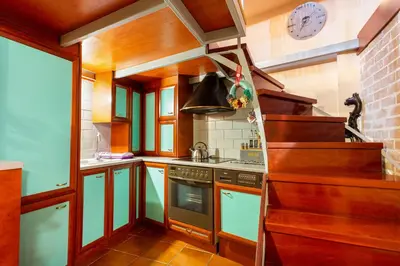 a kitchen with a stove and a clock on the wall at Loft Art Gallery, Chania, Crete in Chania Town