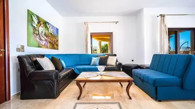 a living room with a blue couch and a table at Grand Olympia,Luxury, spacious indoor&outdoor area in Kissamos