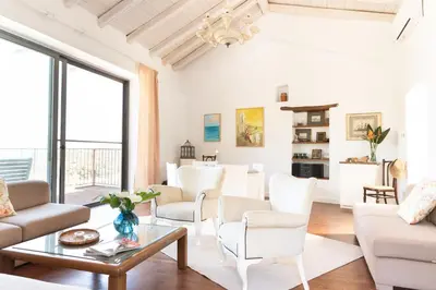a living room with white furniture and large windows at Feána Home by 8essentially in Psathoyiánnos