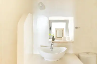 a white bathroom with a sink and a mirror at Feána Home by 8essentially in Psathoyiánnos