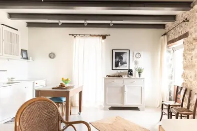 a kitchen with white walls and a table and chairs at Feána Home by 8essentially in Psathoyiánnos