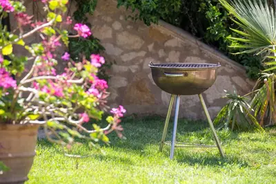 a grill sitting in the grass in a yard at Villa Palma in Maleme