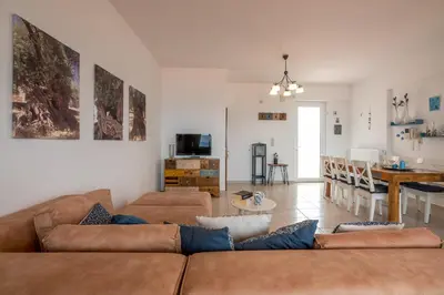 a living room with a couch and a dining room at Agiazi Beachfront Apartment in Chania Town