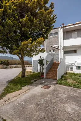 a tree next to a building with a staircase at Agiazi Beachfront Apartment in Chania Town