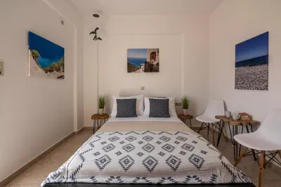 a bedroom with a bed and a table and chairs at Agiazi Beachfront Apartment in Chania Town
