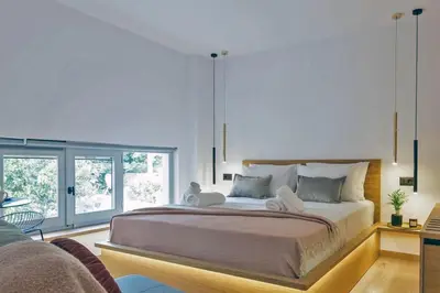 a bedroom with a large bed and a large window at Arch 4 Luxury Living in Chania Town