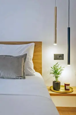 a bedroom with a white bed and a plant on a table at Arch 4 Luxury Living in Chania Town