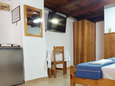 a bedroom with a bed and a television on the wall at Guesthouse Chryssoula in Chania Town