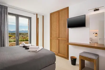 a bedroom with a bed with a tv and a window at Villa Afeidia in Tersanas