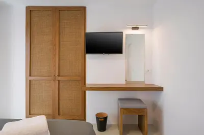 a room with a tv on a wall with a stool at Villa Afeidia in Tersanas