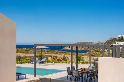 a patio with a table and chairs next to a pool at Villa Afeidia in Tersanas