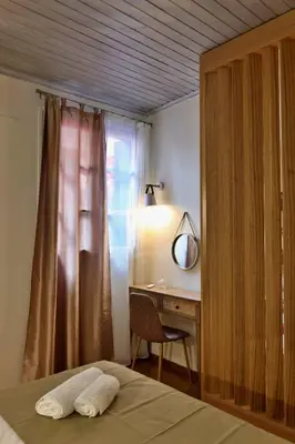 a bedroom with a bed and a desk with a mirror at Helianthi in Chania Town