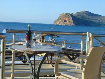 a table with a bottle of wine and two glasses at Comfy Beachfront Litinas Casa with SeaView in Chania Town