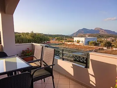 a balcony with a table and chairs and mountains at 