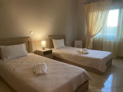 two beds in a hotel room with a window at 