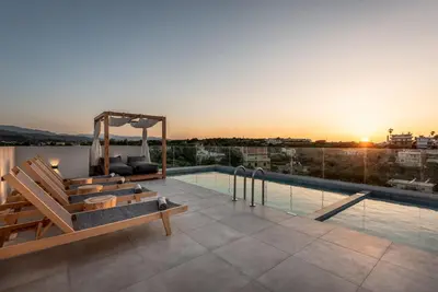 a rooftop pool with benches and a view of the city at Soleado Villa Chania rooftop heated pool in Chania Town