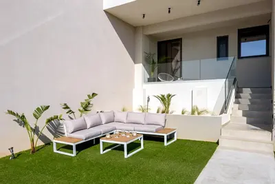 a living room with a couch and a table on grass at Soleado Villa Chania rooftop heated pool in Chania Town