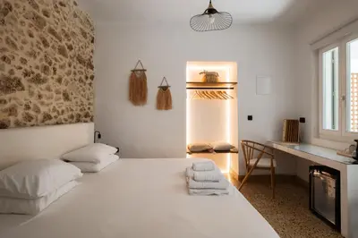 a white bedroom with a bed and a desk at MV Living - Studio in Chania Town