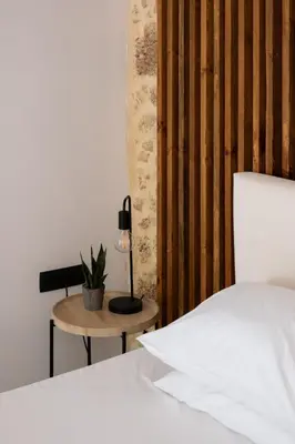 a bedroom with a bed and a table with a lamp at MV Living - Studio in Chania Town