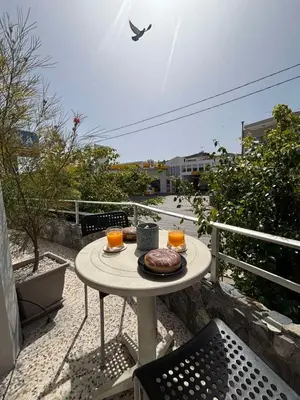 a table with a plate of food on a balcony at ERIS House in Kissamos
