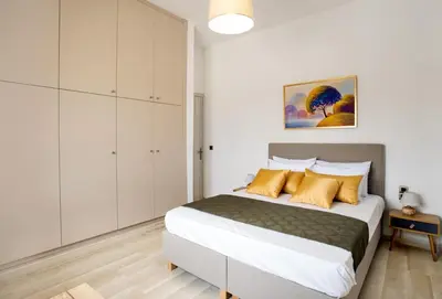 a bedroom with a large bed with yellow pillows at Vagioni Seaside Villa in Kounoupidhianá