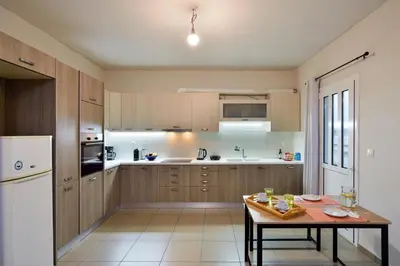 a kitchen with a table and a white refrigerator at Souda apartment in Souda