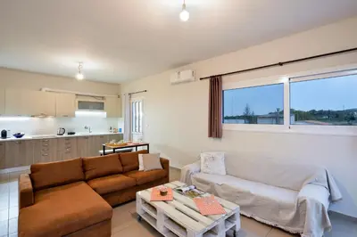 a living room with a couch and a table at Souda apartment in Souda