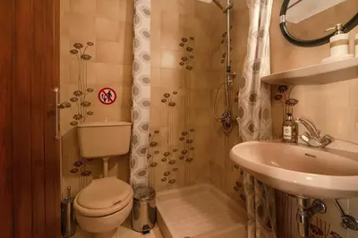 a small bathroom with a toilet and a sink at Calliope Rooms 1 in Kissamos