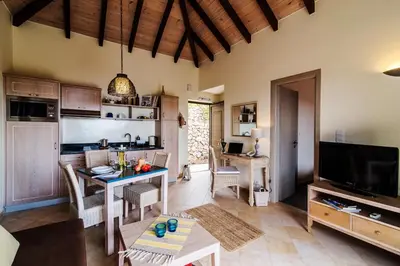 a living room with a table and a kitchen at Christos Place-Anidri in Palaiochóra