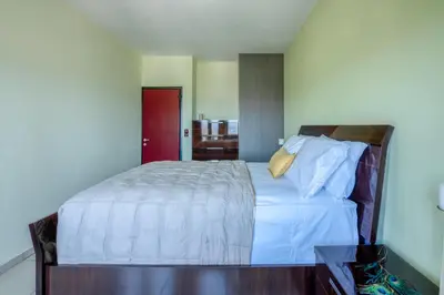 a bedroom with a bed with white sheets and a red door at Michael's Villa in Kissamos