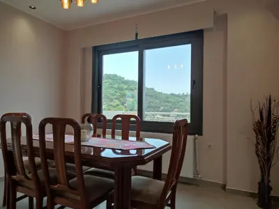 a dining room with a table and chairs and a window at Villa Lakki's Ori in Lákkoi