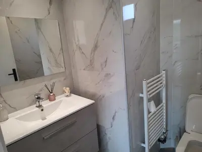 a white bathroom with a sink and a mirror at Villa Lakki's Ori in Lákkoi