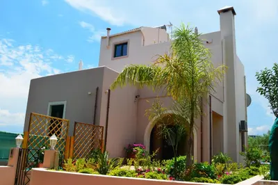 a house with a palm tree in front of it at Belle Verte Villa Maleme in Maleme