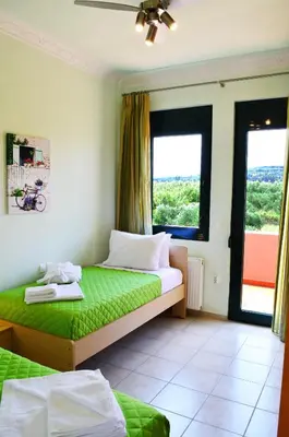 a bedroom with a bed and two windows at Belle Verte Villa Maleme in Maleme