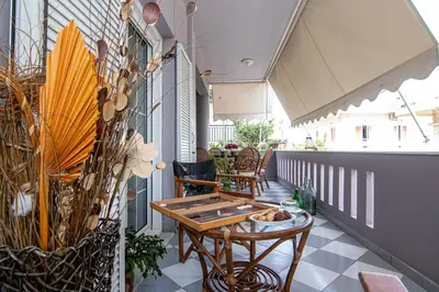 a balcony with a table and chairs and plants at Laurel Heights Apartment in Chania Town