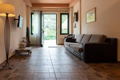 a living room with a couch and a tile floor at Villa Araxovoli in Palaiochóra