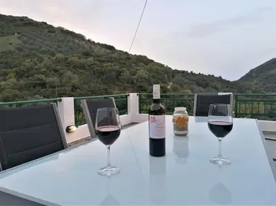 two glasses of wine sitting on a table with a bottle of wine at Villa Araxovoli in Palaiochóra
