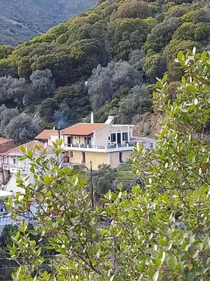 a house on top of a mountain with trees at Villa Araxovoli in Palaiochóra