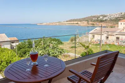 a wooden table with two wine glasses on a balcony at Aura Estate in Chania Town