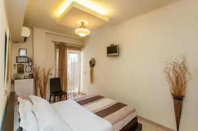 a bedroom with a bed and a chair in it at Downtown apartment in Chania in Chania Town