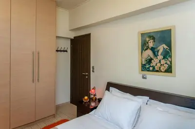 a bedroom with a bed and a painting on the wall at Downtown apartment in Chania in Chania Town