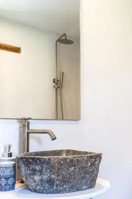 a bathroom with a stone sink and a mirror at Armenous Green Dia's Mansion in Arménoi