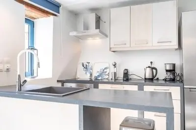 a kitchen with white cabinets and a sink at Armenous Green Dia's Mansion in Arménoi