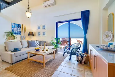 a living room with a couch and a table at Beach House Kalamaki steps away from the beach in Galatás